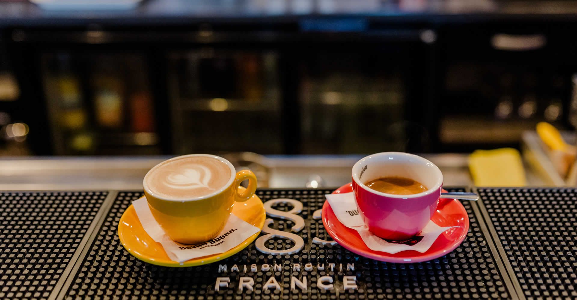 Imagine reprezentand doua cesti de cafea pe un bar